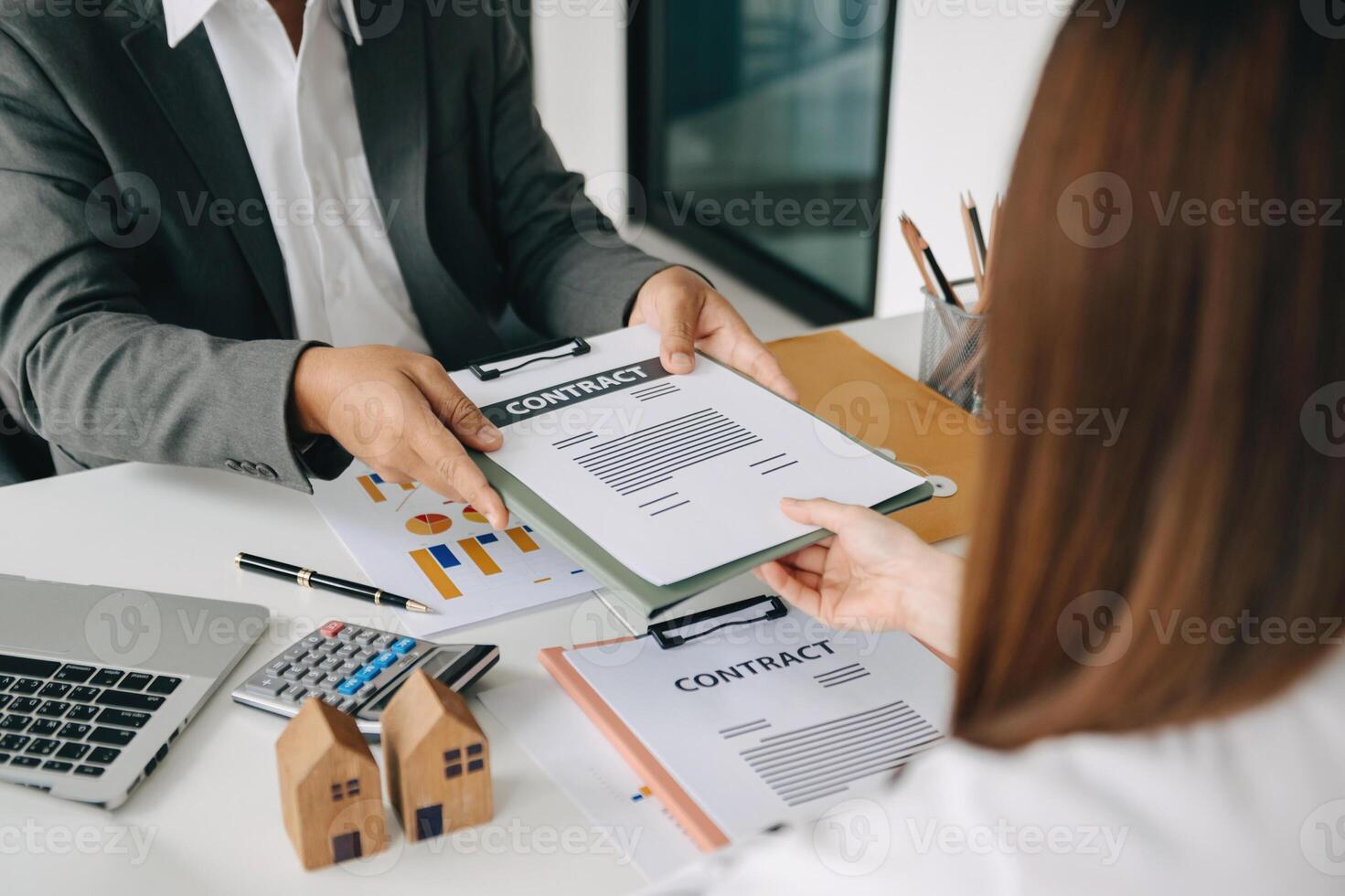 Signing a contract. Client and broker agent, lease agreement, successful deal and  Young business sitting at the desk in office photo