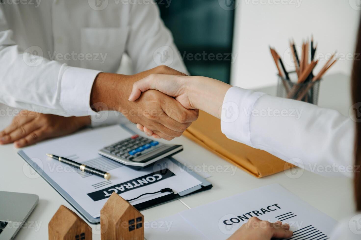 Signing a contract. Client and broker agent, lease agreement, successful deal and  Young business sitting at the desk in office photo
