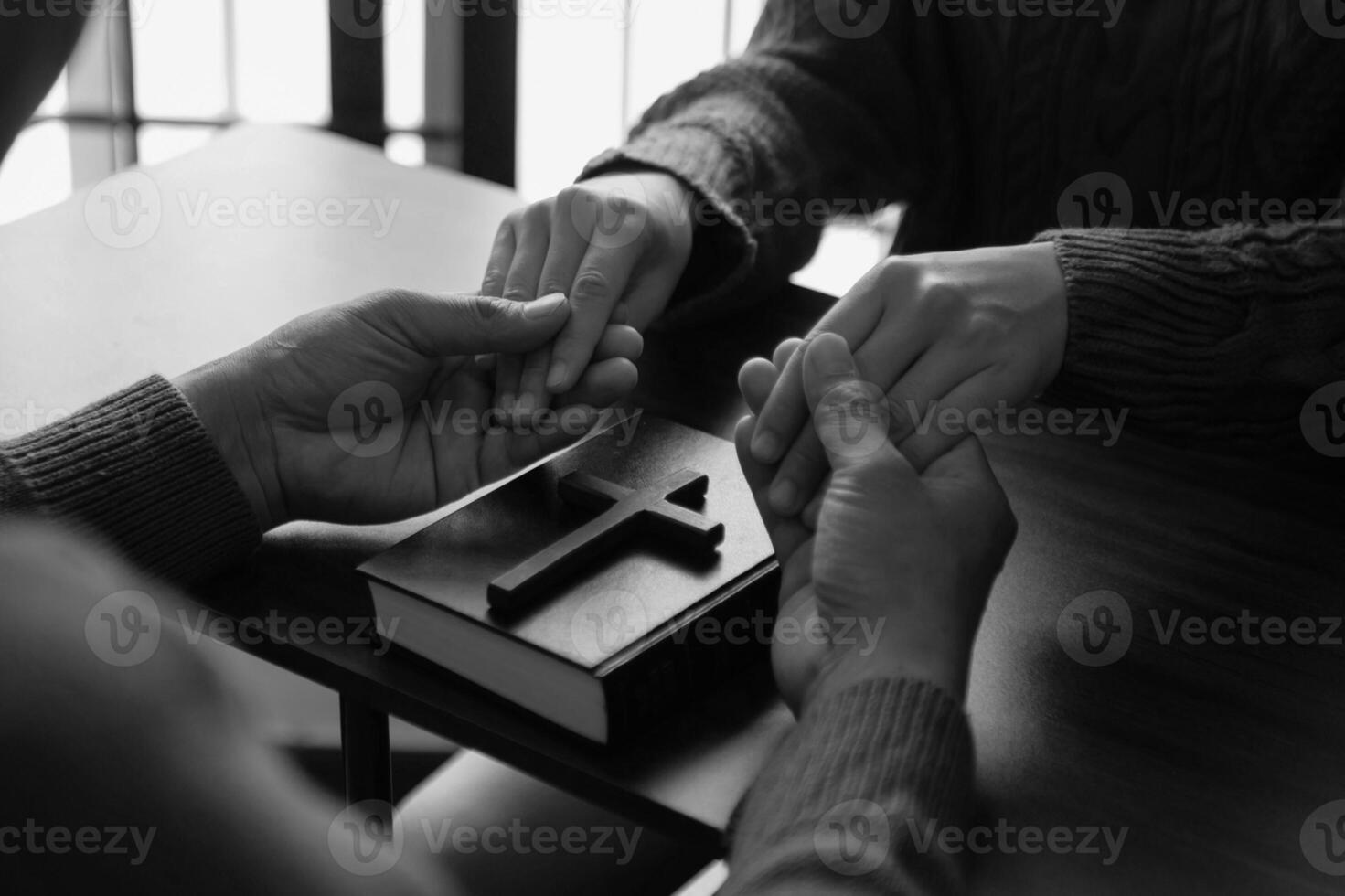 Two people reading and study bible in home and pray together.Studying the Word Of God With Friends. in sun light photo