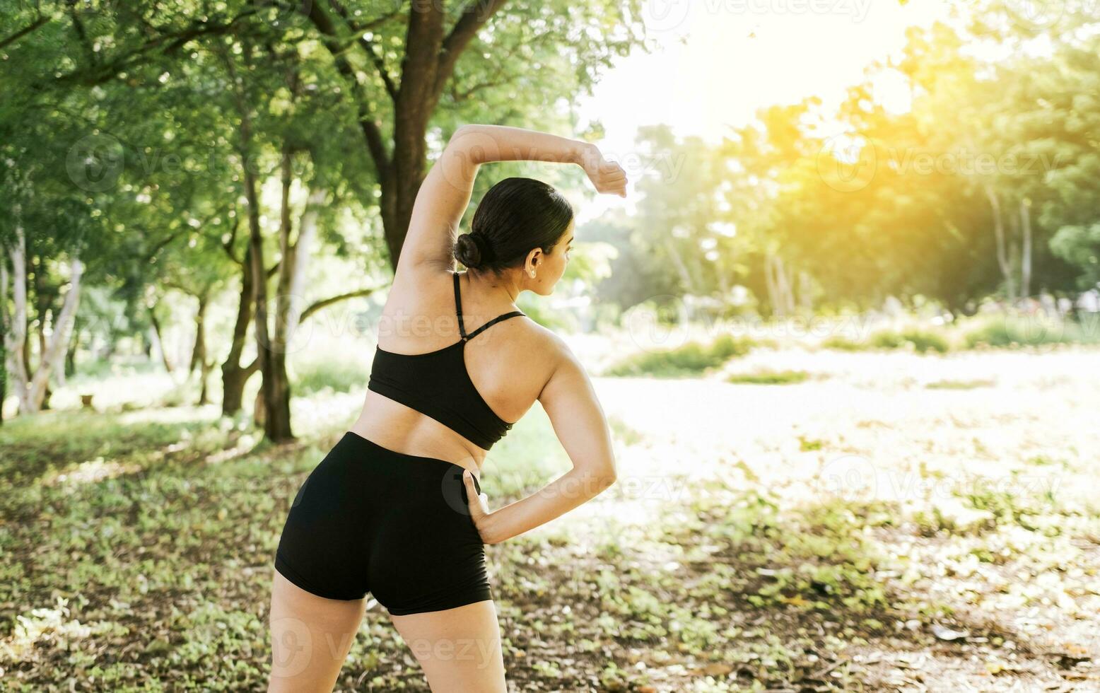 Athlete girl stretching arms before running. Concept of physical activity and healthy life, Athlete girl doing warm-up exercises in a park, Sporty woman doing stretching exercises before running photo