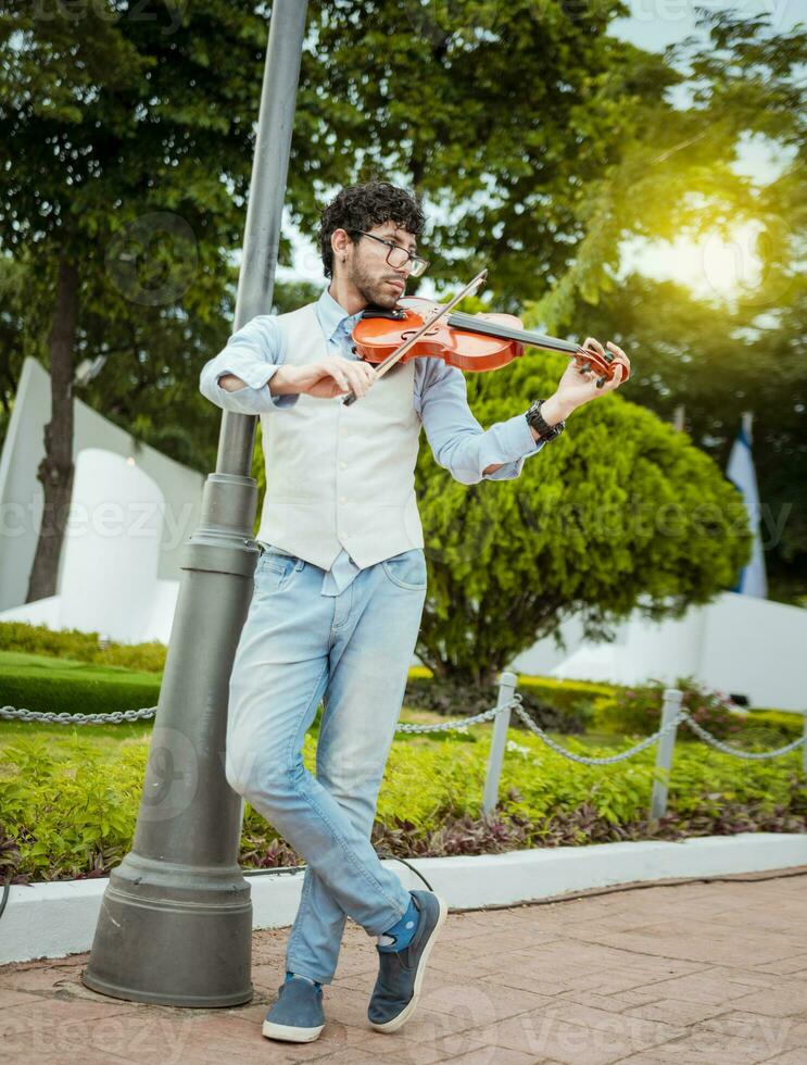 hombre jugando violín en el calle. retrato de hombre jugando violín en el calle. chaqueta artista jugando violín al aire libre, imagen de un persona jugando violín al aire libre foto