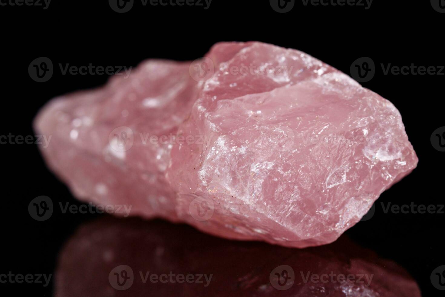Macro mineral stone Pink quartz on black background photo