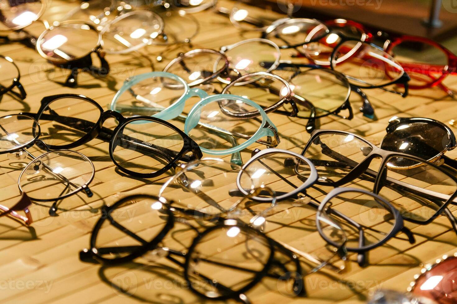 large selection of sunglasses and glasses on a stand photo