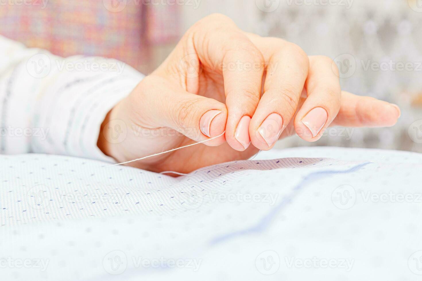 Female hands of a master tailor at work, a sewing machine needle photo