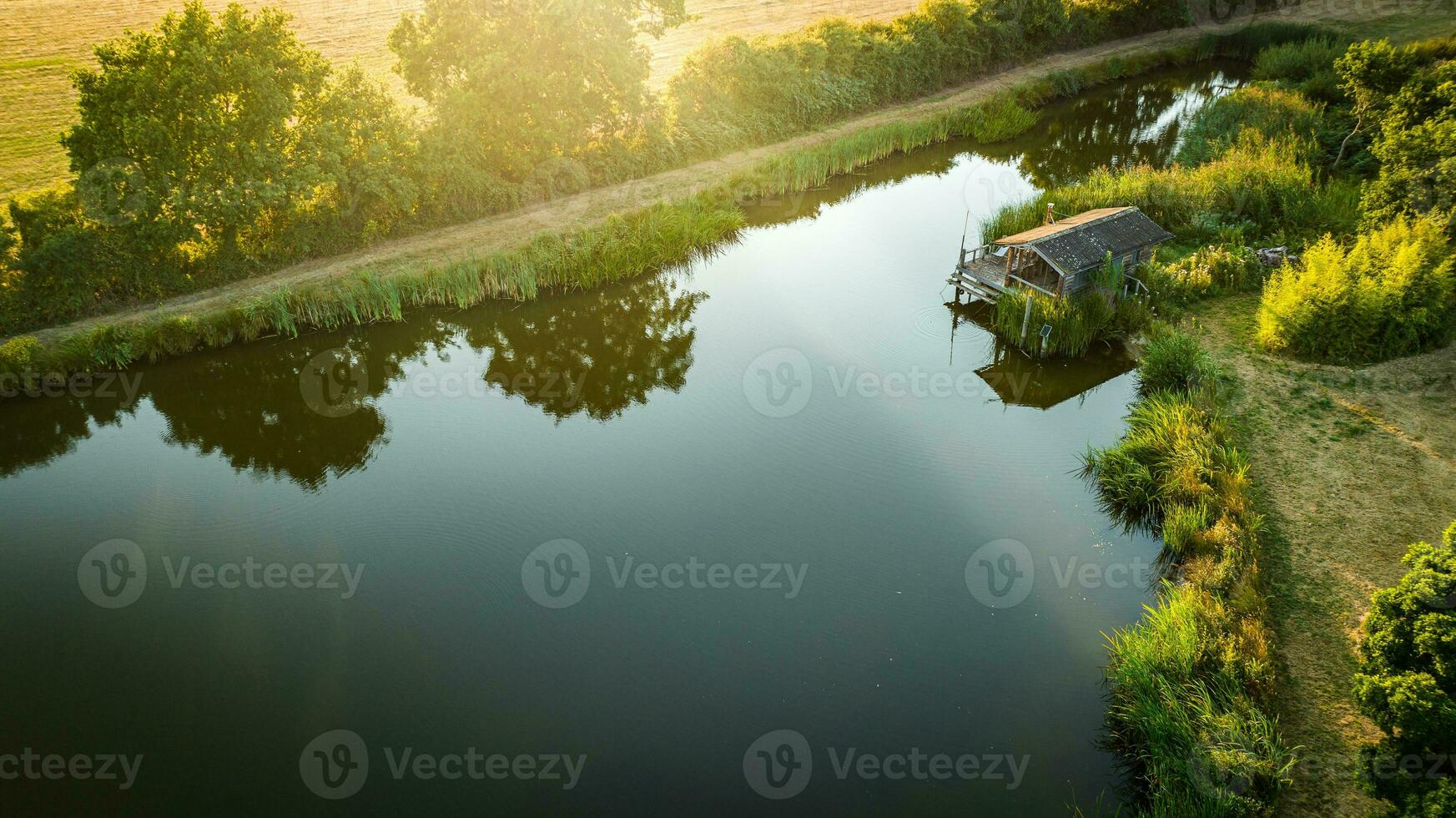 pequeño lago en el granja con un pequeño pescar choza en el lado foto