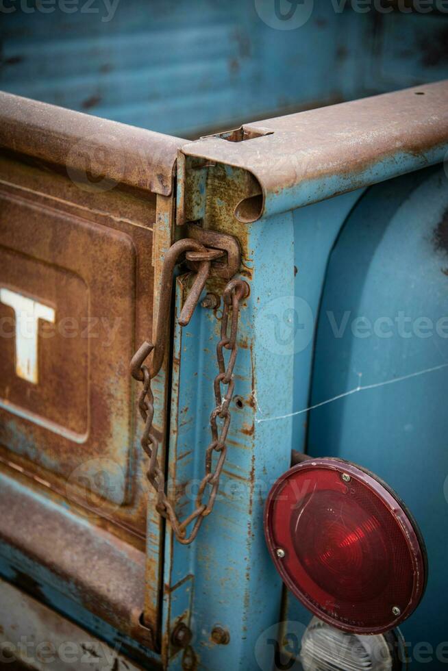 Rusty iron lock on wooden yellow rear gate of truck photo