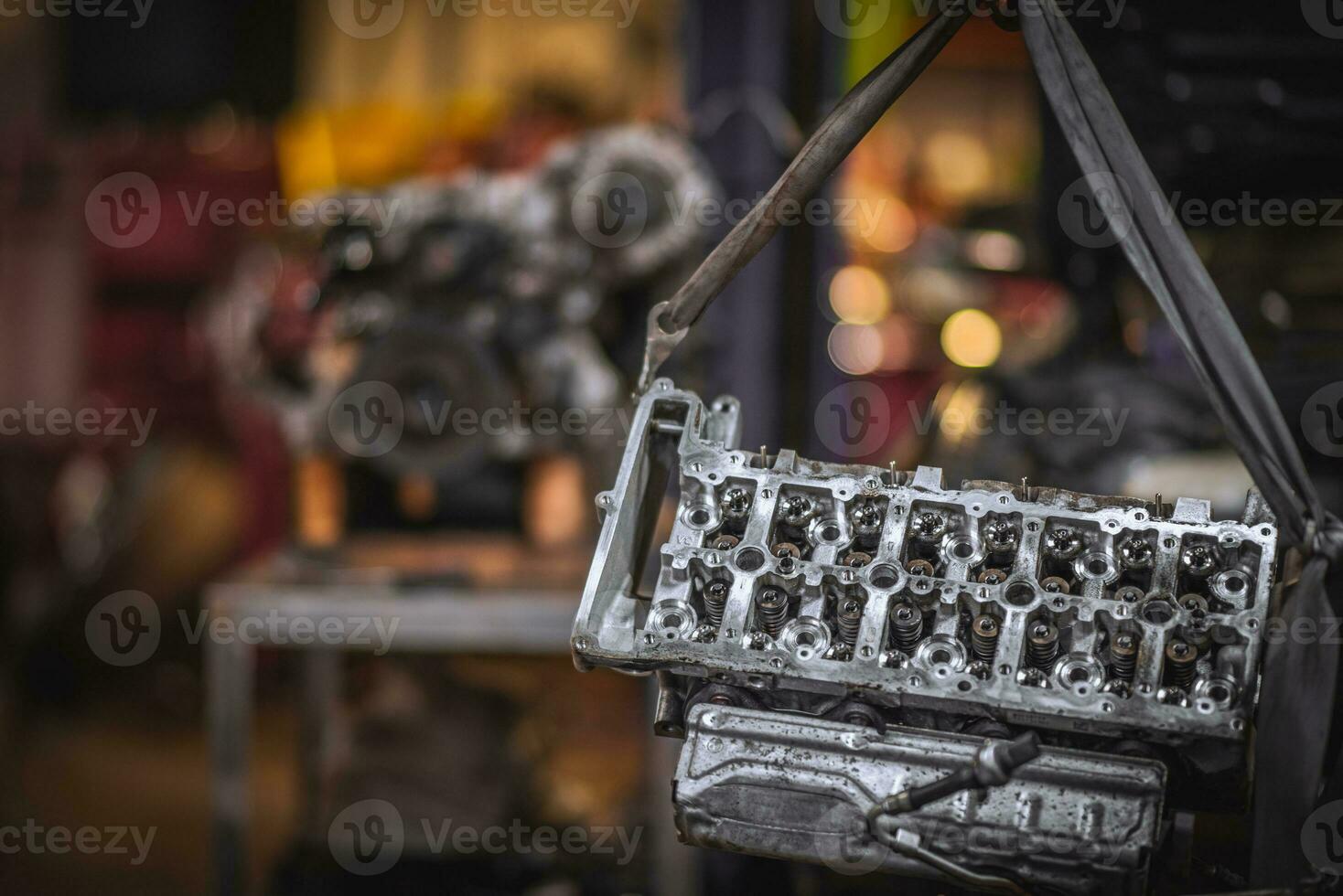 Cylinder head repaired waiting to go on an engine block in background photo