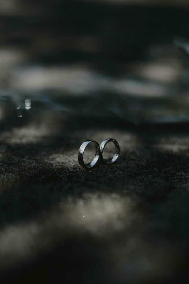 two wedding rings sitting on the ground photo