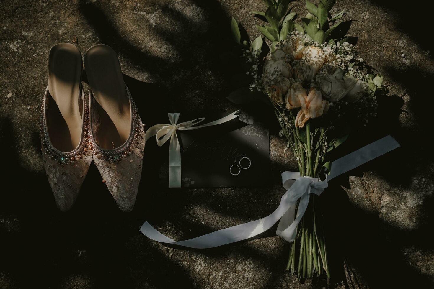 wedding shoes and bouquet on stone photo