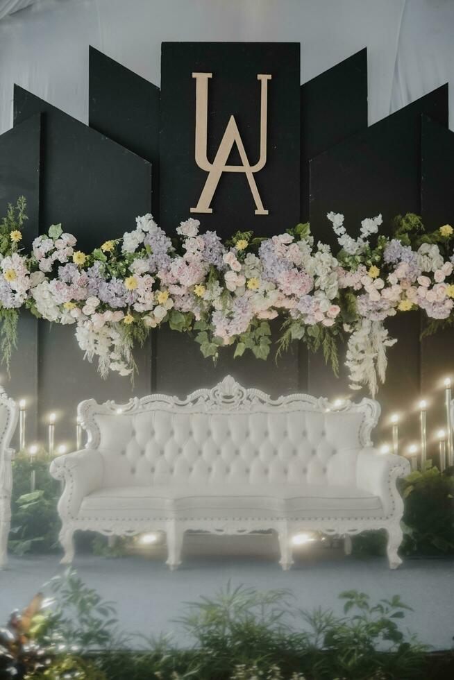 a black and white stage with flowers and a white couch photo