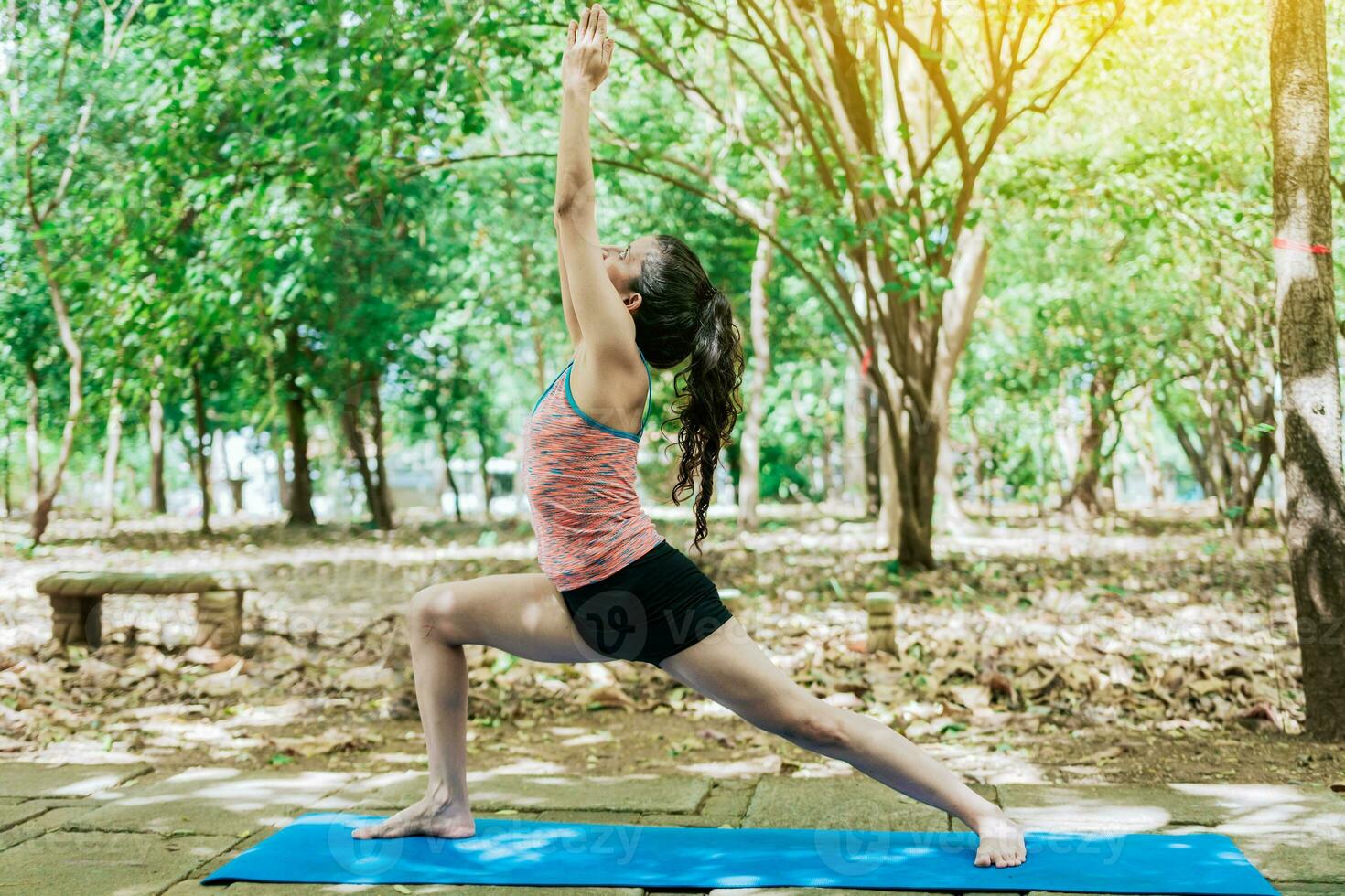 joven mujer haciendo yoga guerrero yo pose. niña practicando virabhadrasana yoga al aire libre. foto