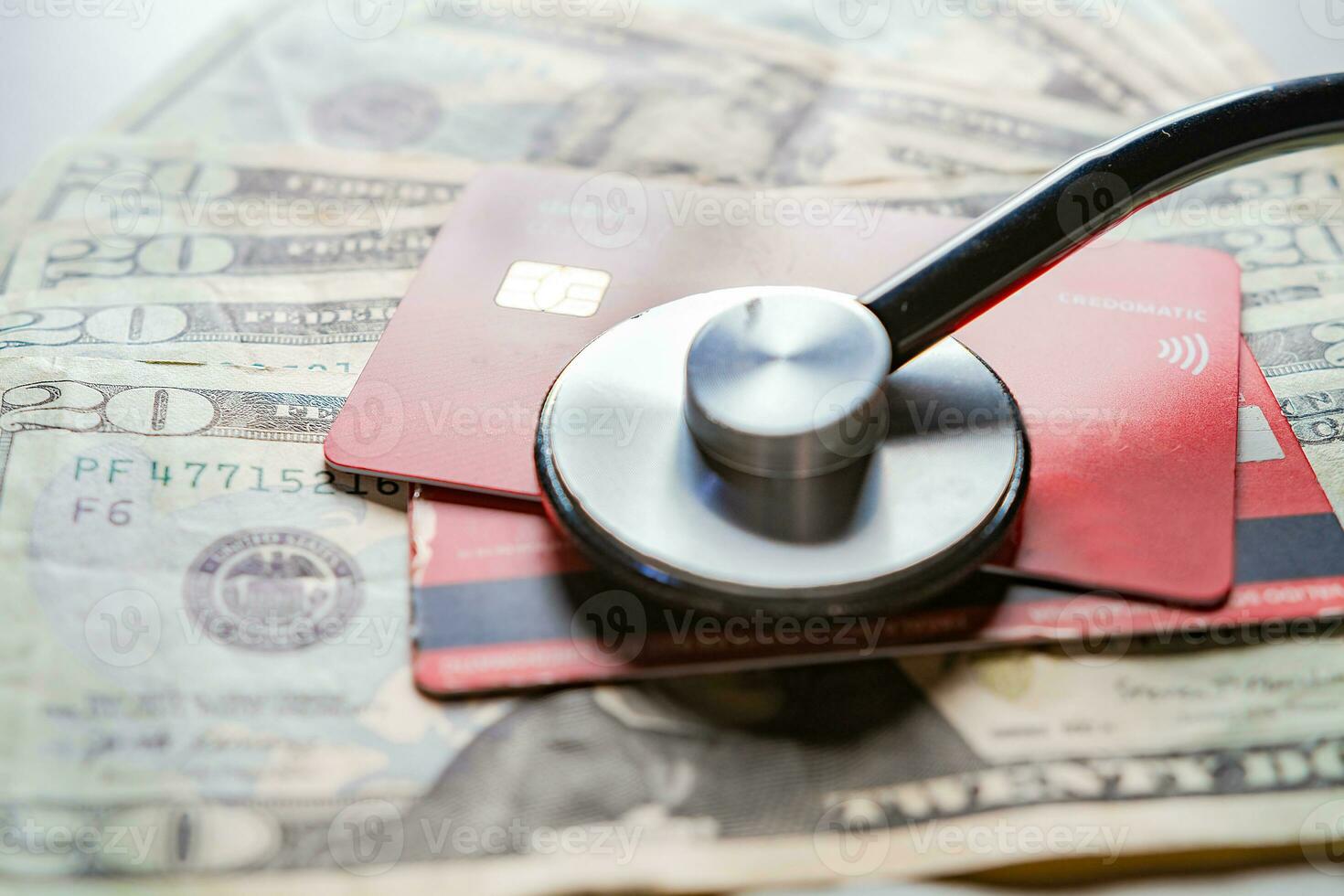 Stethoscope with bank notes and credit card. Stethoscope on credit card with dollar bills, Concept of online medical payments with credit card photo