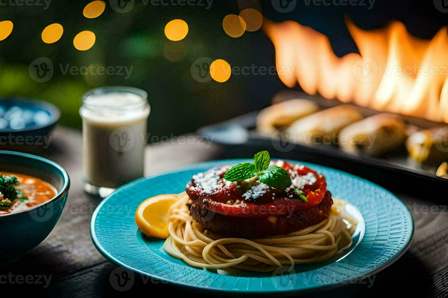 a plate of spaghetti and a bowl of soup next to a fire. AI-Generated photo