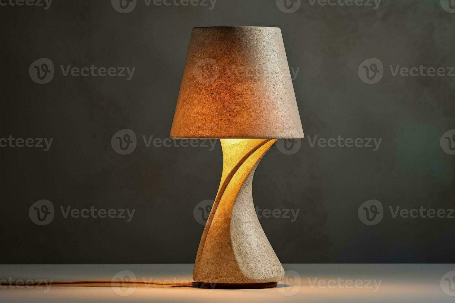 Contemporary concrete table lamp exuding soft light isolated on a gradient background photo