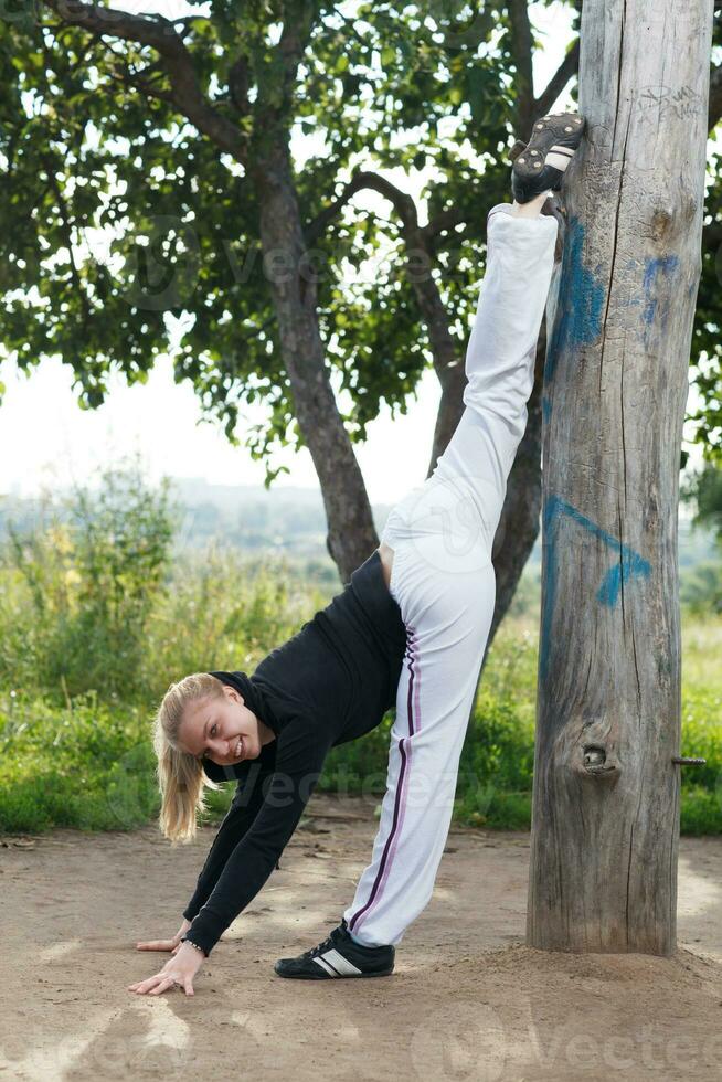 niña hace gimnasio división en el ciudad parque foto