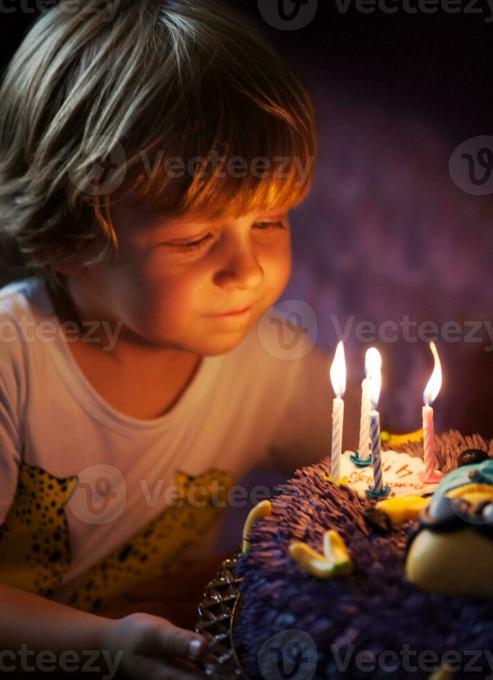 Little boy blows out candles on his birthday photo