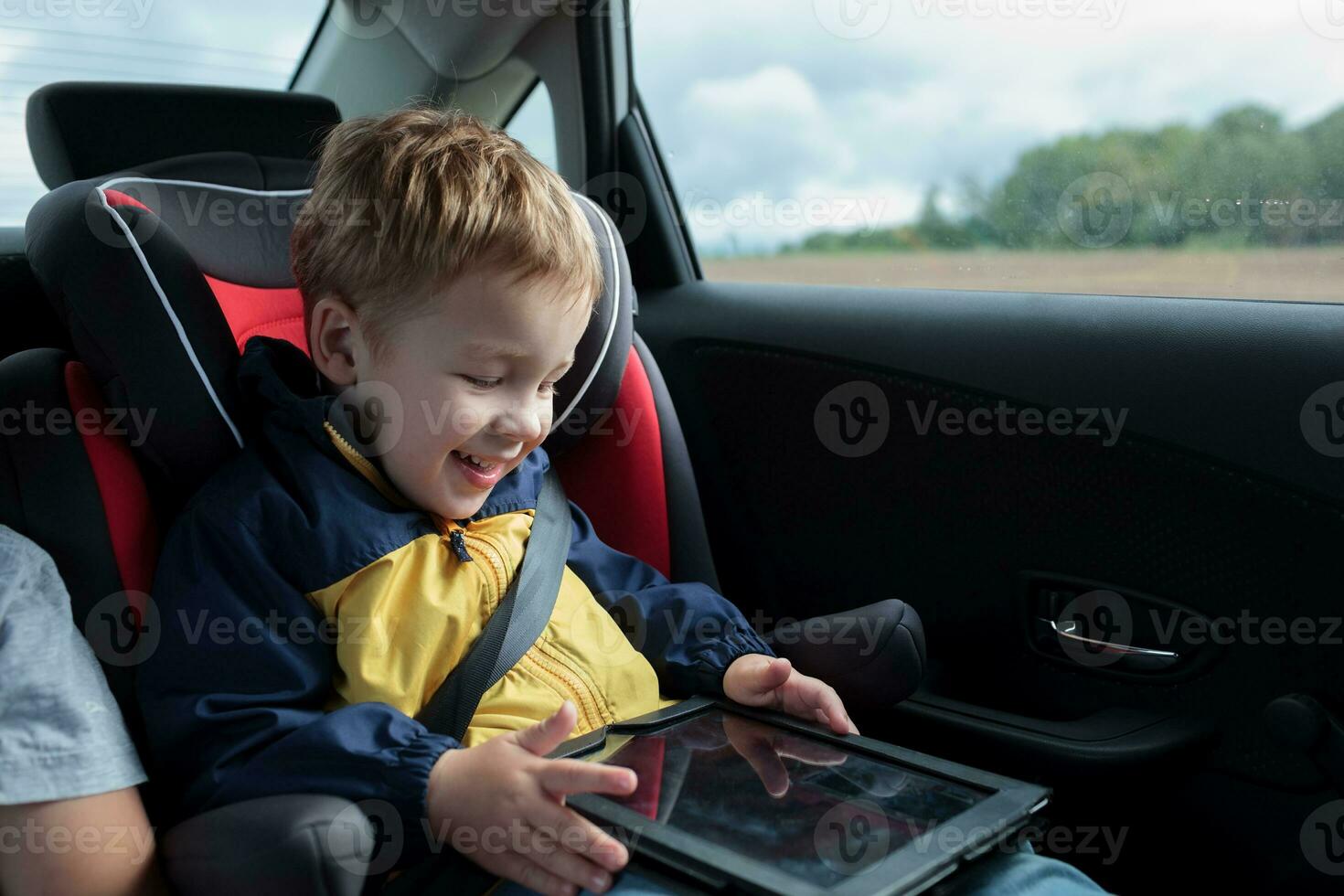 Happy boy playing with touchpad in the car photo