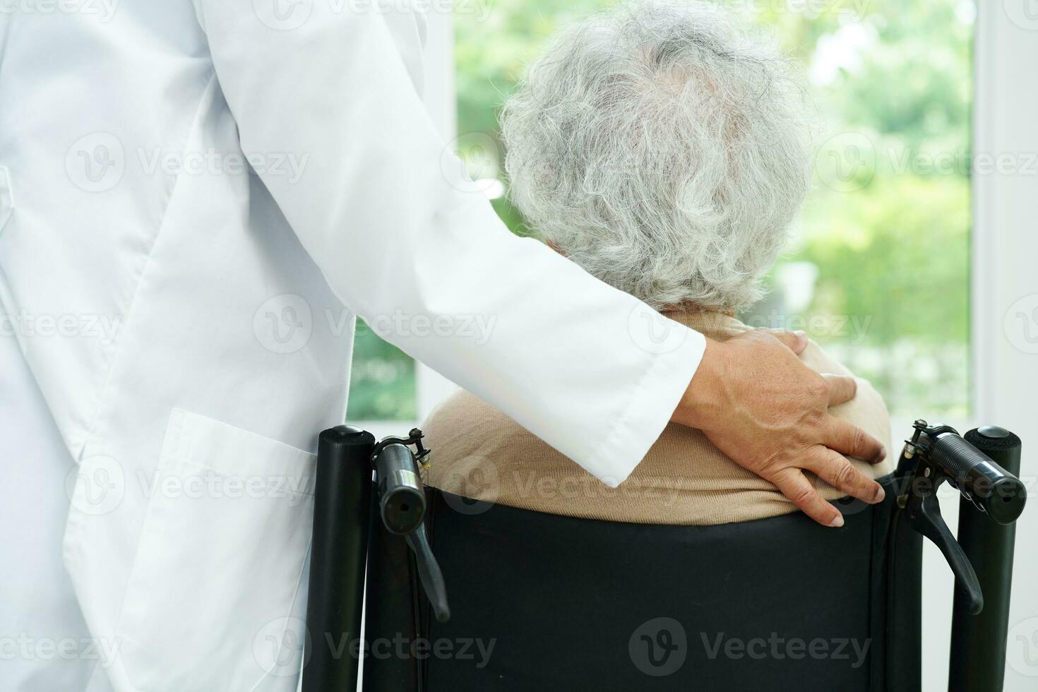 Doctor help Asian elderly woman disability patient sitting on wheelchair in hospital, medical concept. photo