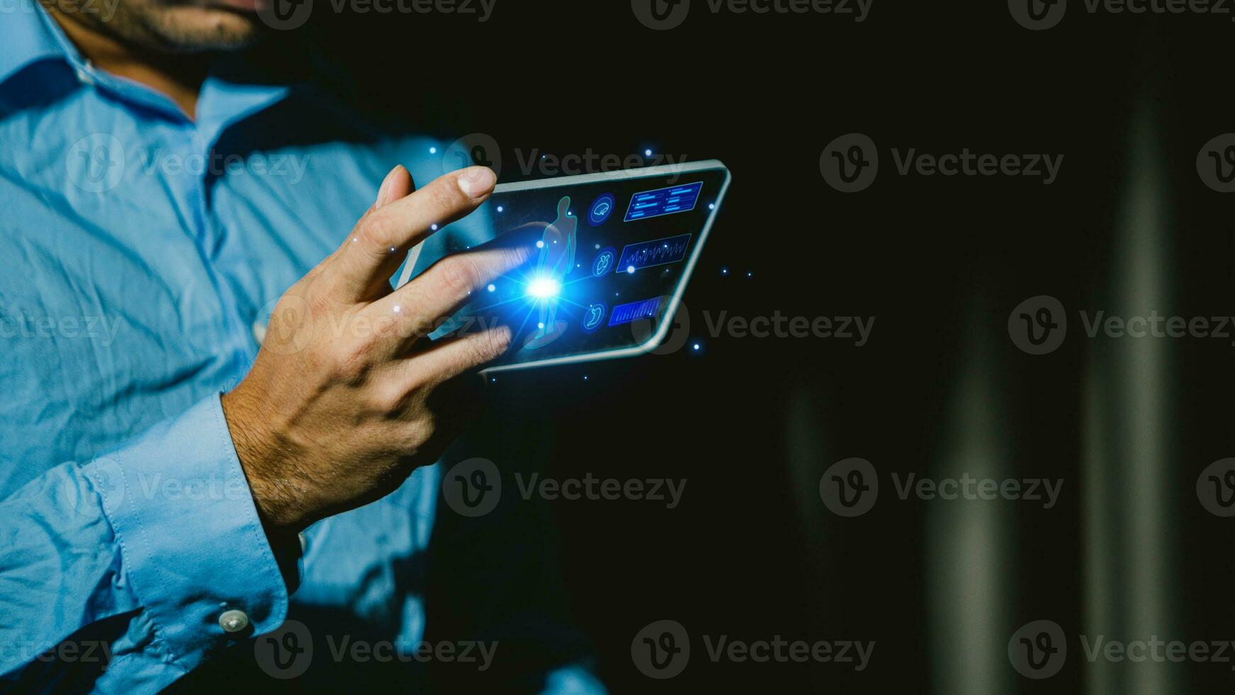 Businessman using tablet computer in dark room. Business and technology concept. photo