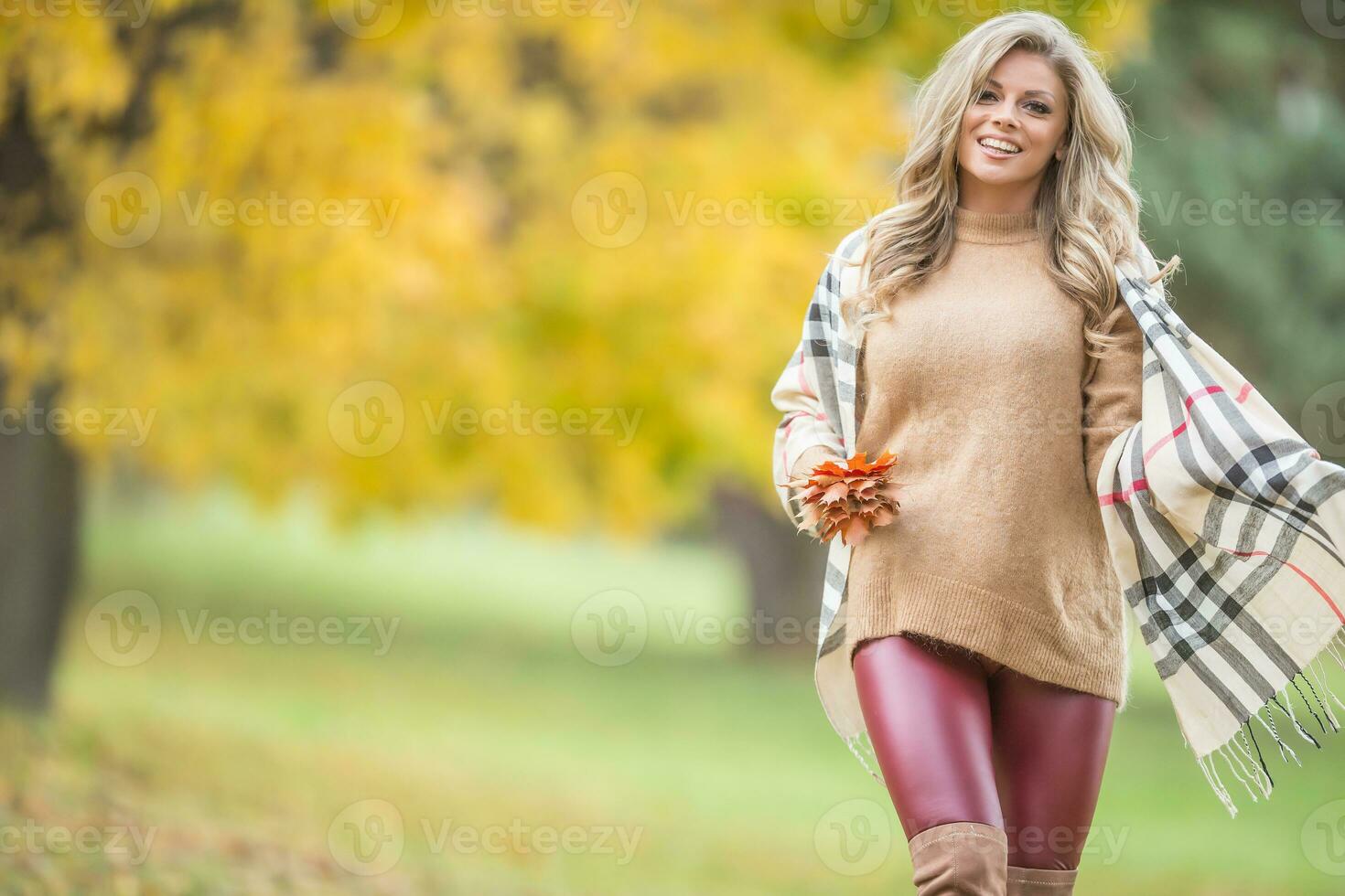 joven mujer en otoño atuendo emocional caminar en parque foto