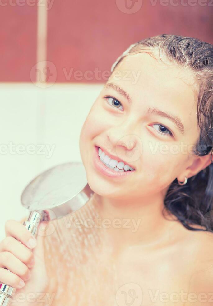 Teenage girl in bathroom is showering. Morning and evening hygiene photo