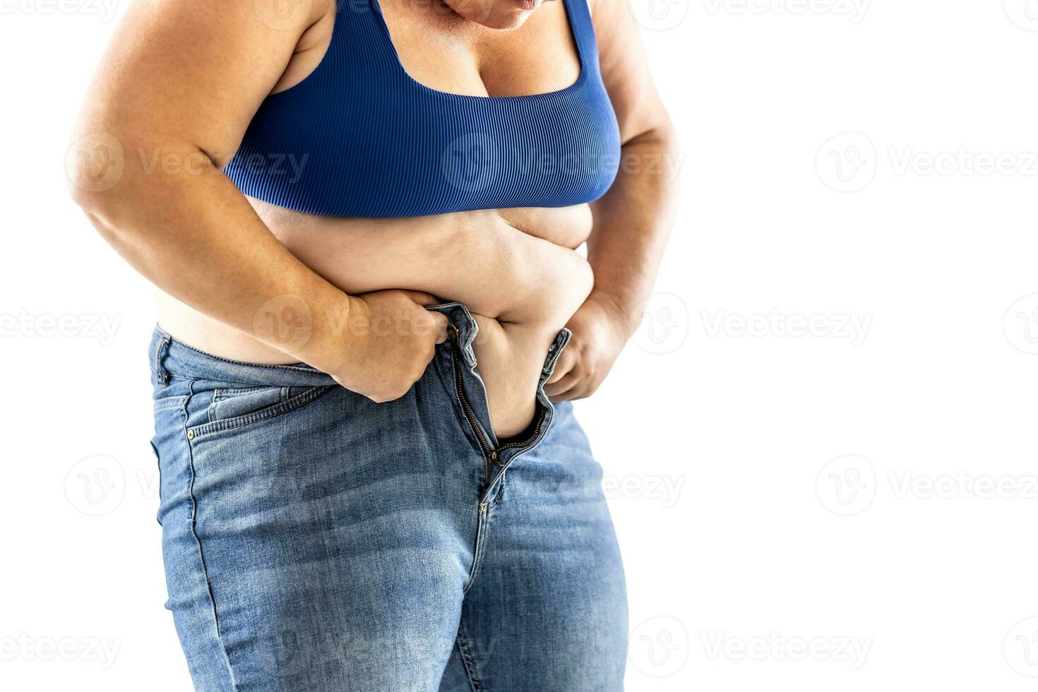 A fat woman has trouble buttoning her jeans - Isolated on white photo