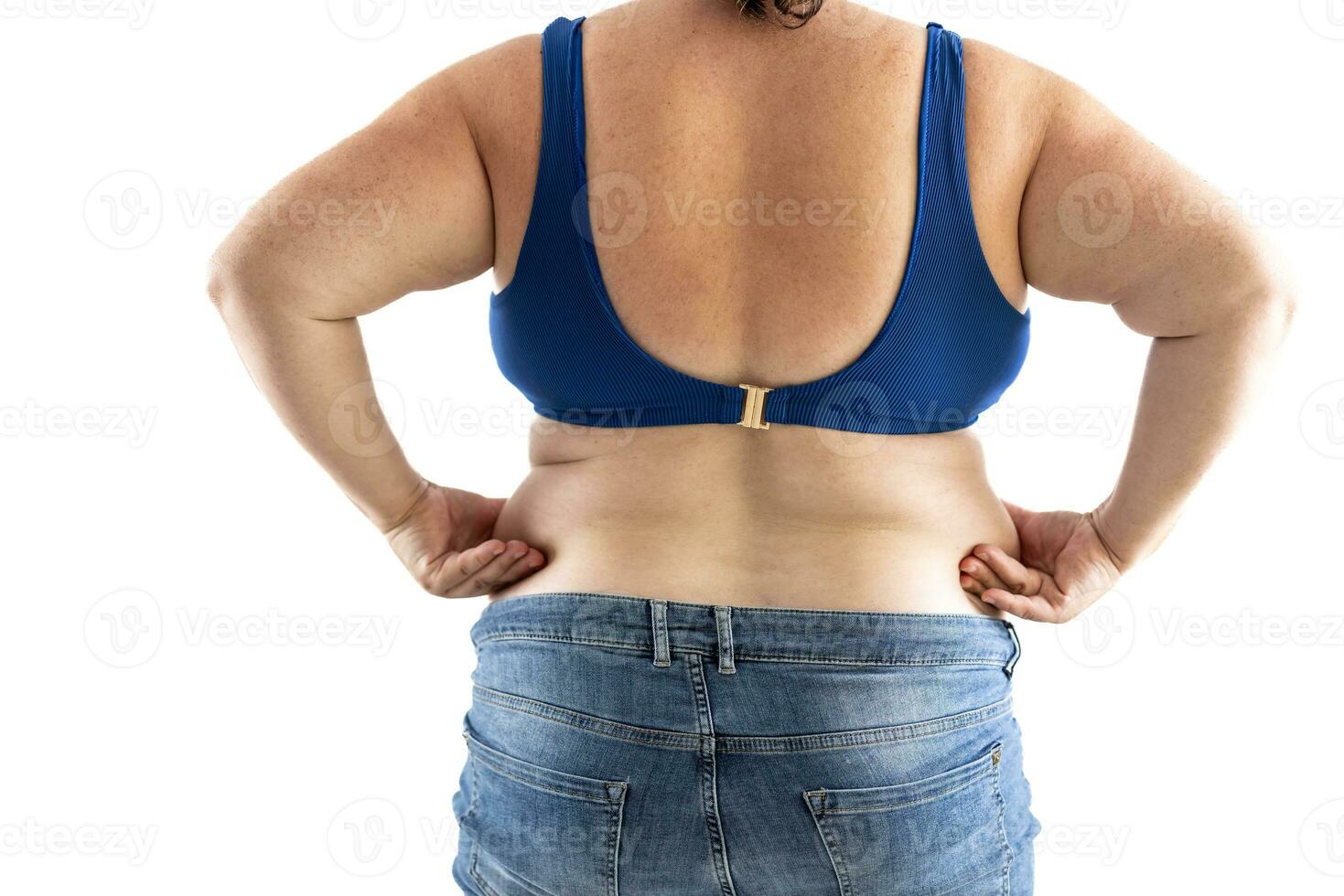 Plus size overweight woman holds her hips full of fat - Isolated on white photo