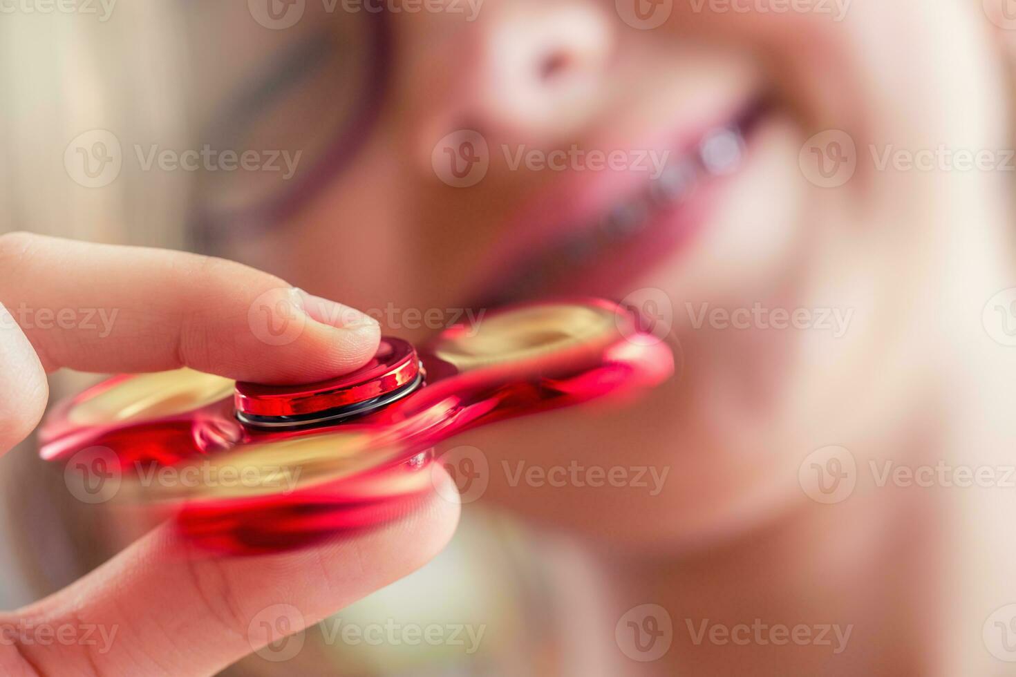Fidget Spinner. Cute young girl playing with fidget spinner. photo