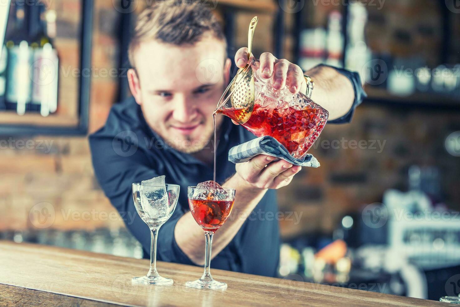 Bartender pouring cocktail alcoholic drink Manhattan. photo