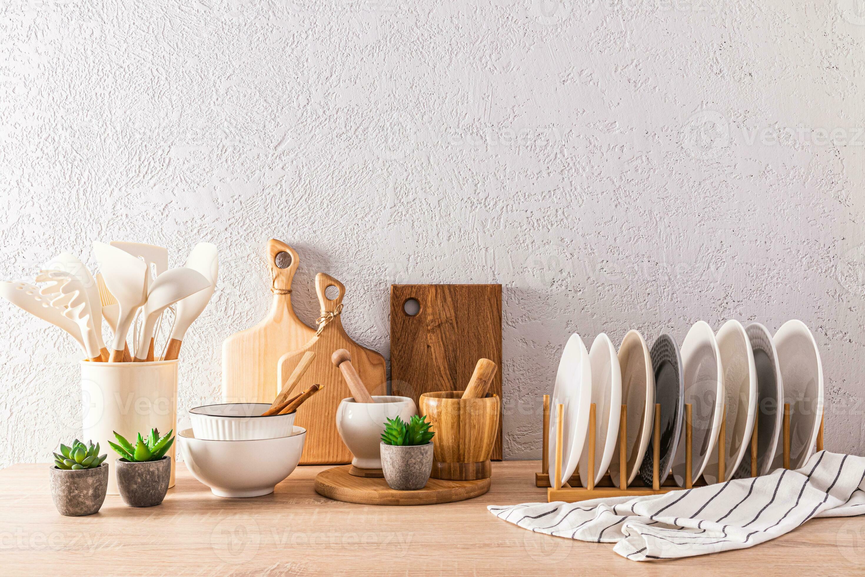 White ceramic utensils and kitchen utensils on a wooden countertop