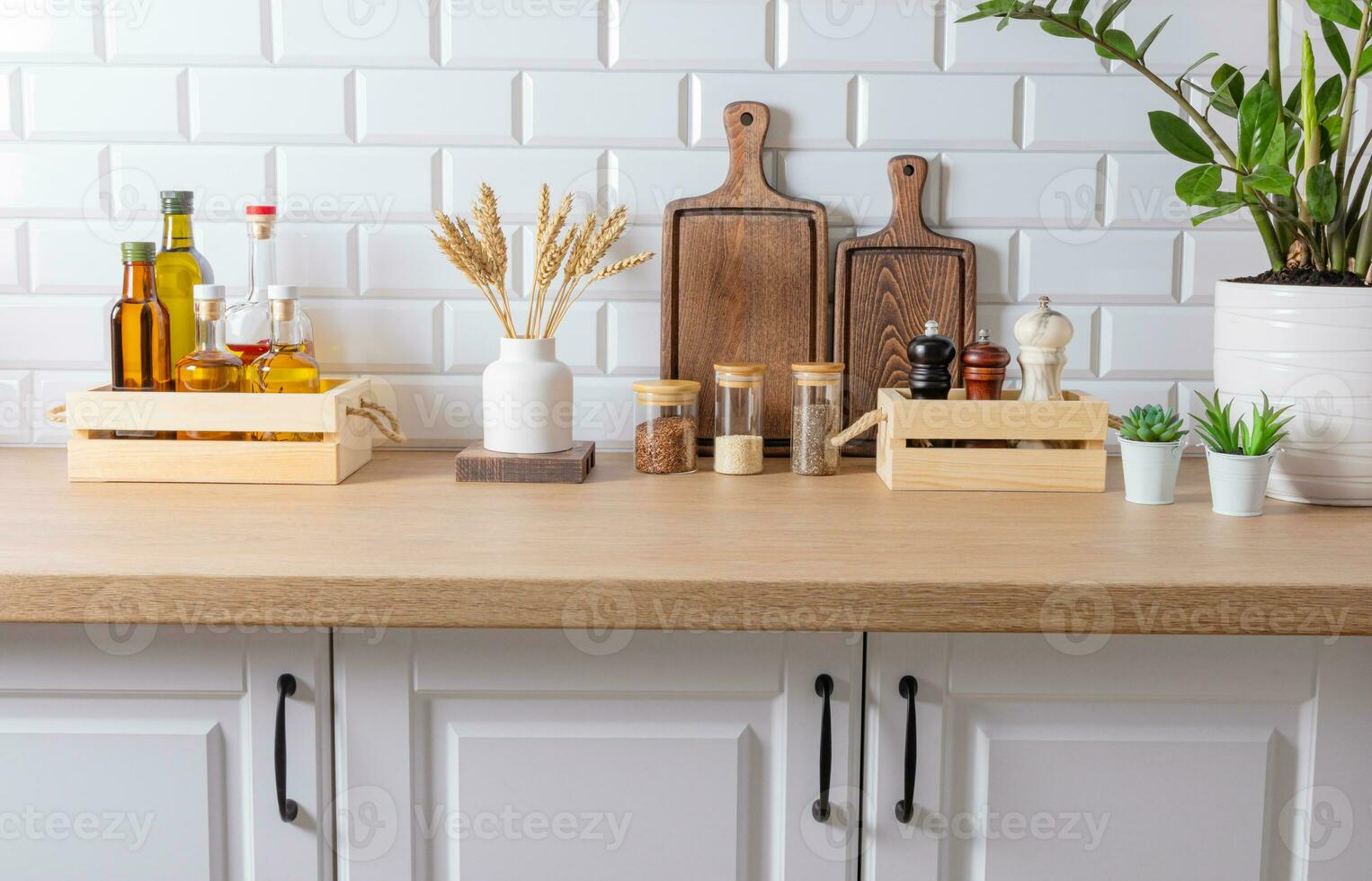 Storage area for spices and oil in various containers and in environmentally friendly wooden boxes on the kitchen countertop. front view. photo