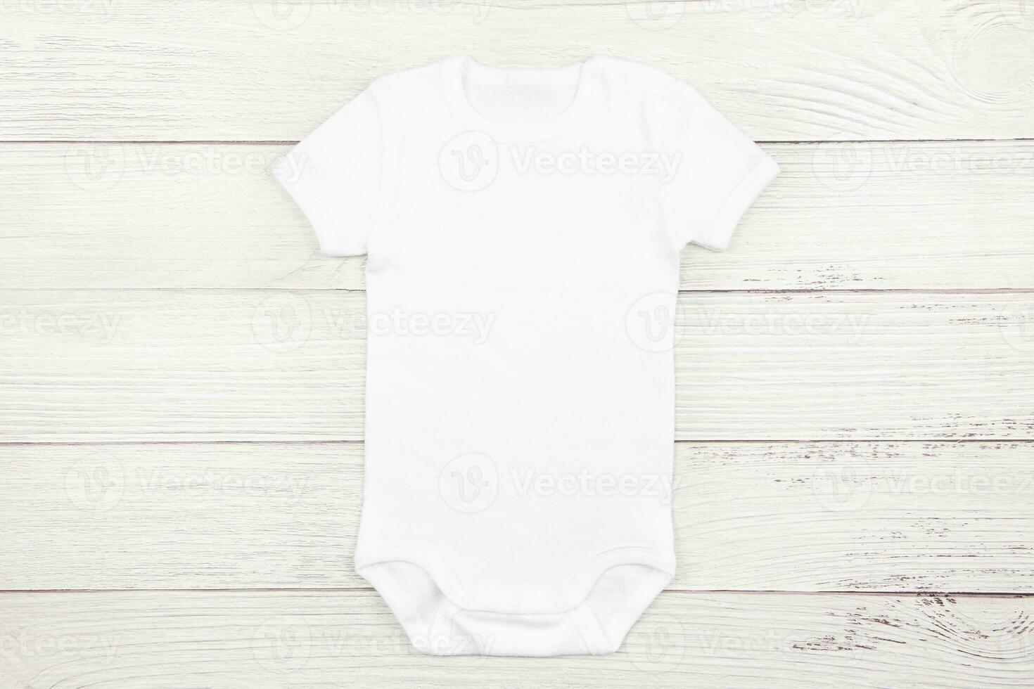 White baby girl or boy bodysuit mockup flat lay on wooden background. Design onesie template, print presentation mock up. Top view. photo
