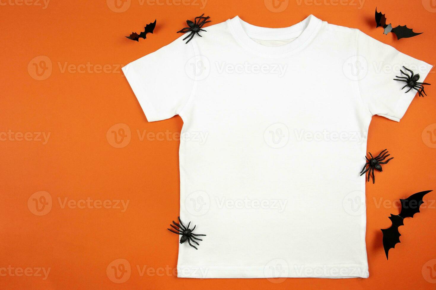 White womens cotton t-shirt halloween mockup with spiders and bats on orange background. Design t shirt template, print presentation mock up. Top view flat lay. photo