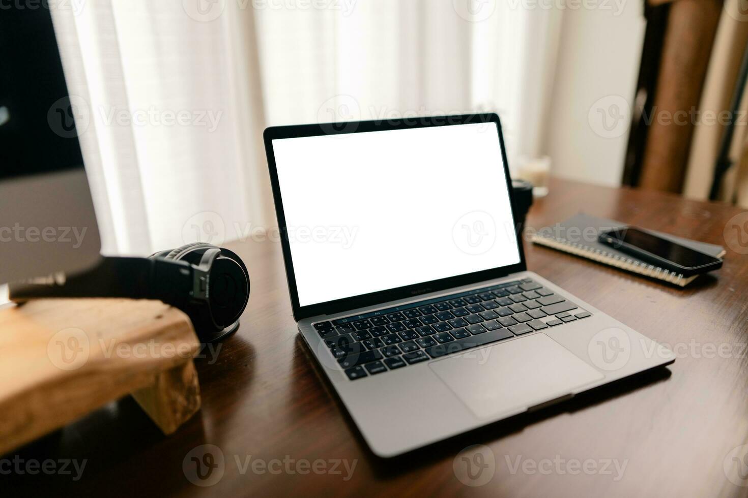 Laptop with blank screen on wooden table photo