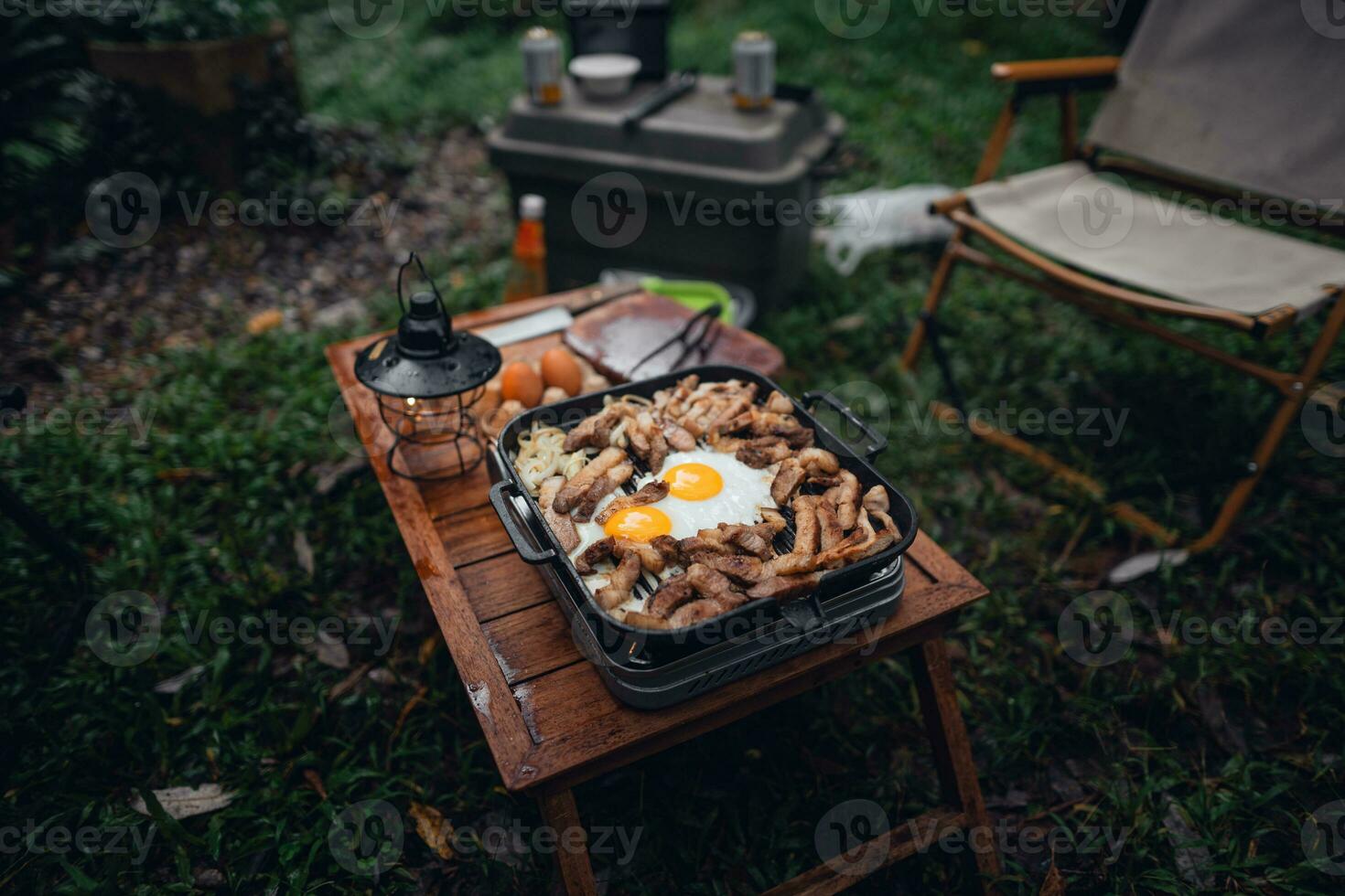 Fried eggs and grilled pork in a camping pan photo