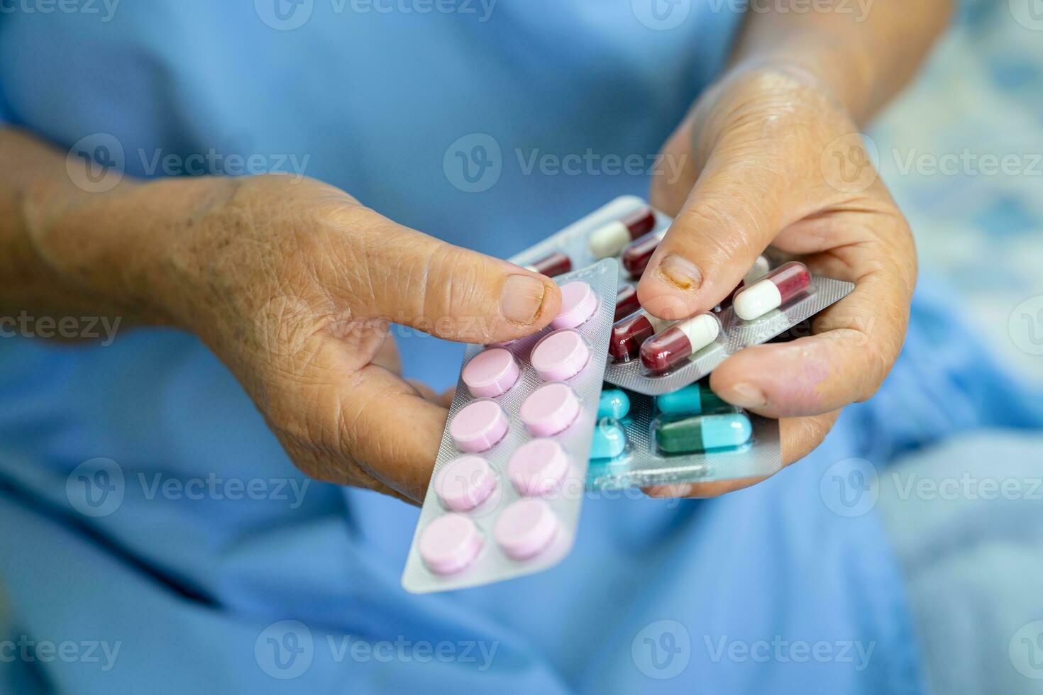 Asian elderly woman patient holding drug in her hand, healthy strong medical concept. photo