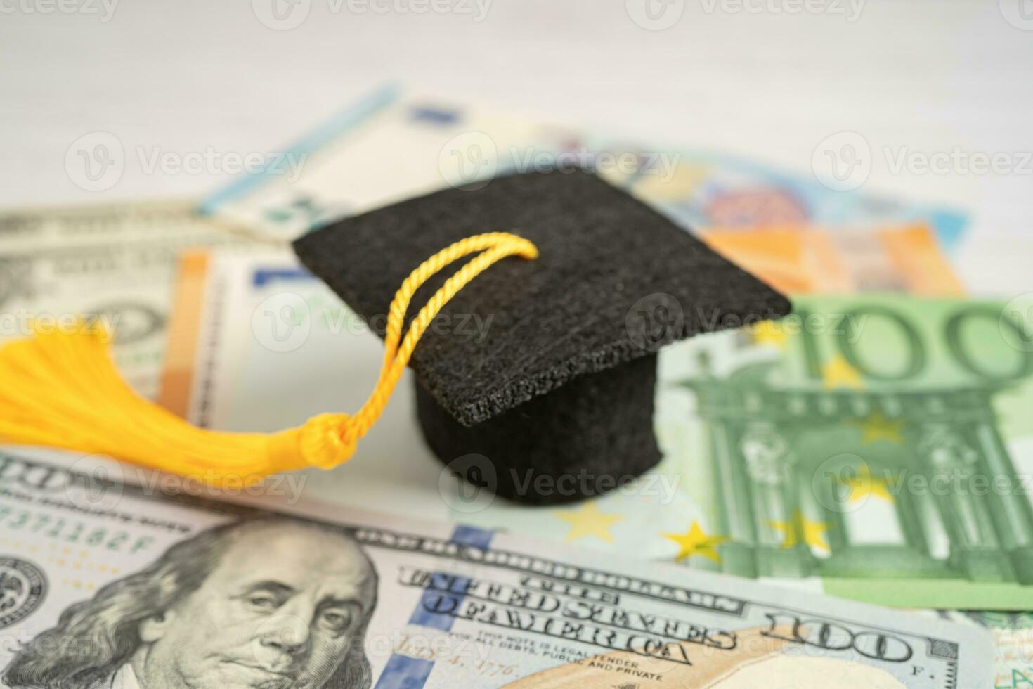 Sombrero de brecha de graduación en billetes de euro y dólar estadounidense, concepto de enseñanza de aprendizaje de tarifa de estudio de educación. foto