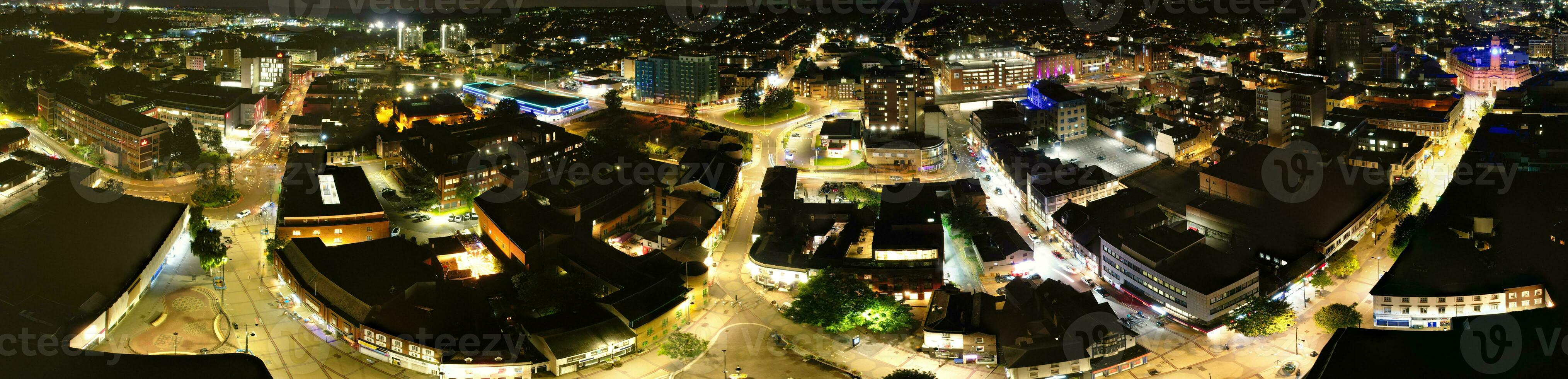 Ultra Wide Aerial Panoramic View of Illuminated Downtown Buildings, Roads and Central Luton City of England UK at Beginning of Clear Weather's Night of September 5th, 2023 photo