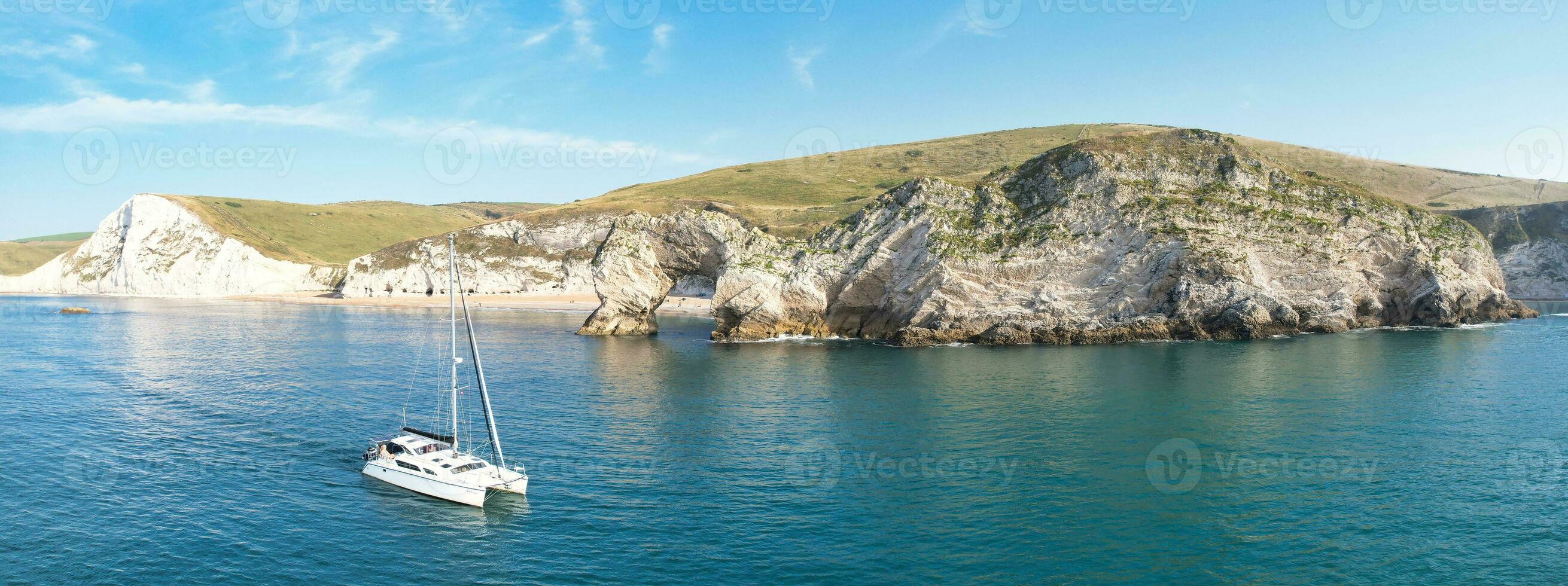 People at Most Beautiful High Angle View of British Landscape and Sea View of Durdle Door Beach of England Great Britain, UK. Image Was captured with Drone's camera on September 9th, 2023 photo