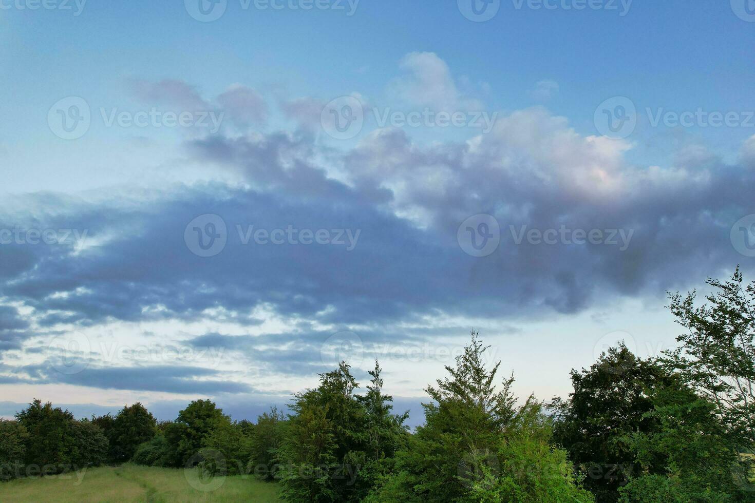 Most Beautiful High Angle view of Dramatical Sky and Clouds over British Countryside Landscape During Sunset photo