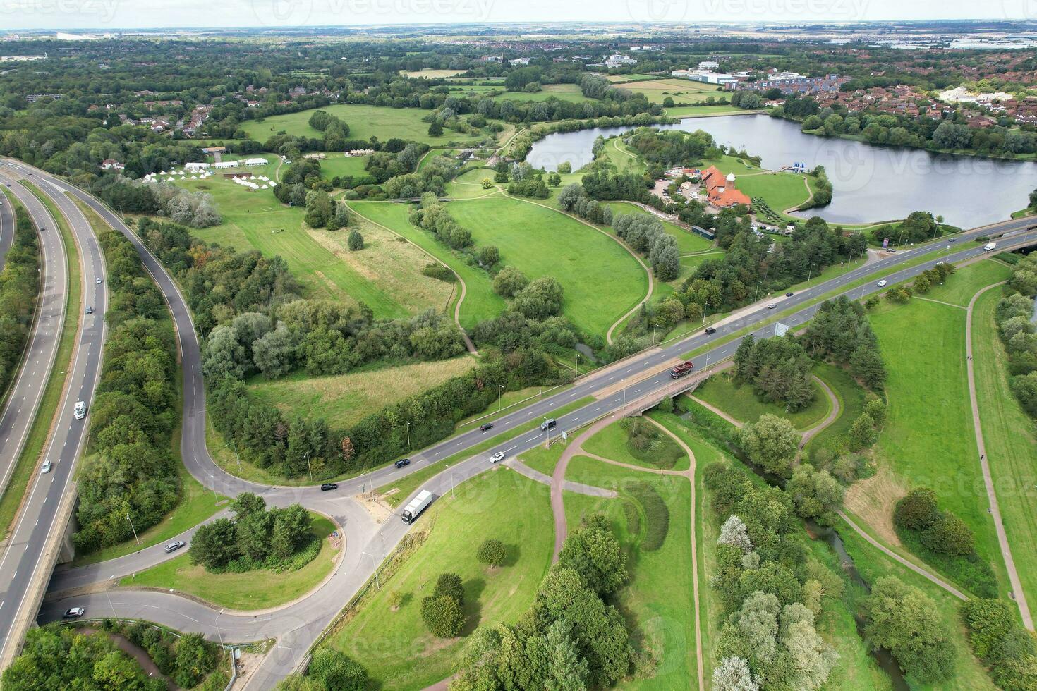 High Angle Footage of British Road and Traffic at Caldecotte Lake of Milton Keynes City of England Great Britain, Beautiful View Captured on August 21st, 2023 with Drone's Camera During Sunny Day photo