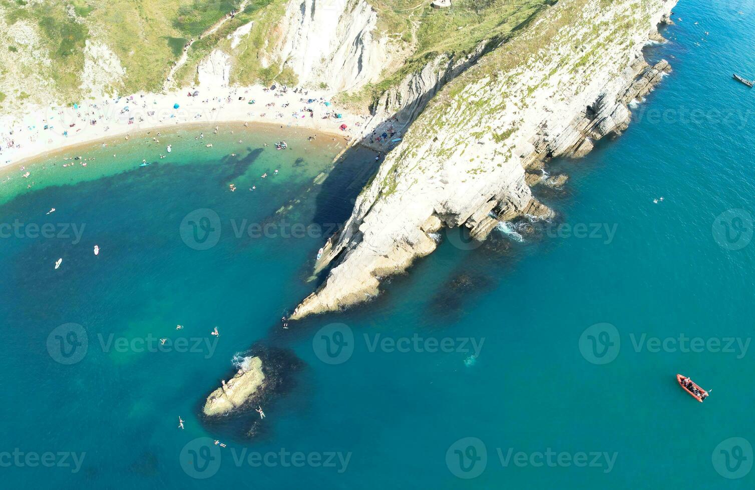 People at Most Beautiful High Angle View of British Landscape and Sea View of Durdle Door Beach of England Great Britain, UK. Image Was captured with Drone's camera on September 9th, 2023 photo