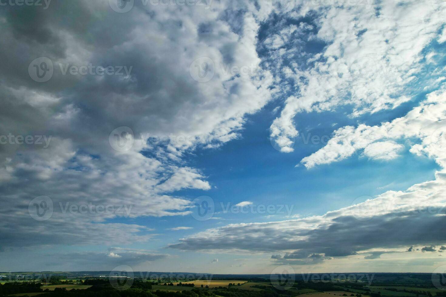 Most Beautiful High Angle view of Dramatical Sky and Clouds over British Countryside Landscape During Sunset photo
