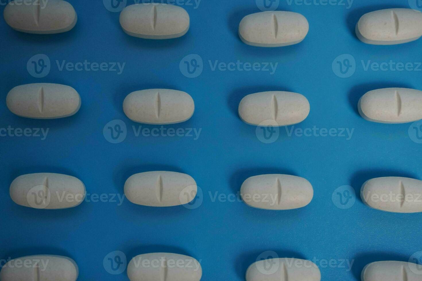 pattern made with Pharmaceutical medicine pills, tablets and capsules on blue background. photo