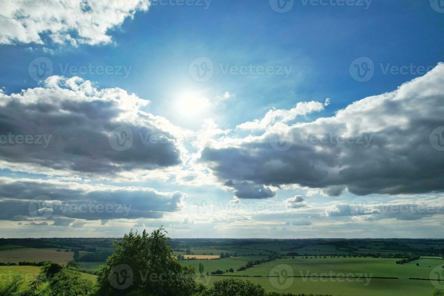 Most Beautiful High Angle view of Dramatical Sky and Clouds over British Countryside Landscape During Sunset photo