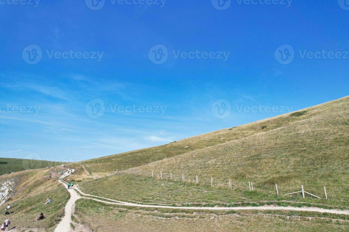 High Angle View of People are Approaching to Durdle Door Beach Which is Most Famous Tourist Attraction Place Through Walking Distance over Landscape and Hills. Captured on September 9th, 2023 photo