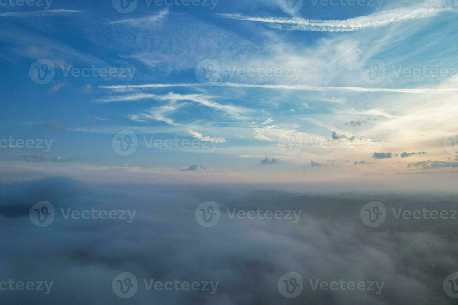 Most Beautiful and Best High Angle Dramatical Colourful Sky Footage from Above The Clouds. The Fast Moving Clouds During Sun rising Early in the Morning over Luton City of England UK photo