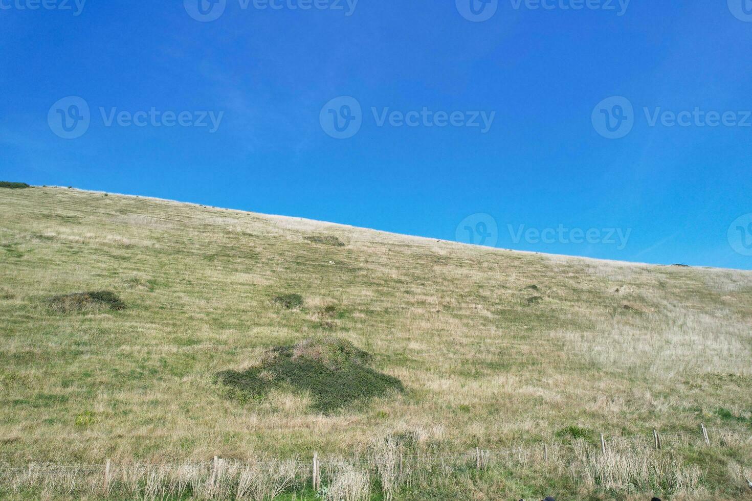 High Angle View of People are Approaching to Durdle Door Beach Which is Most Famous Tourist Attraction Place Through Walking Distance over Landscape and Hills. Captured on September 9th, 2023 photo