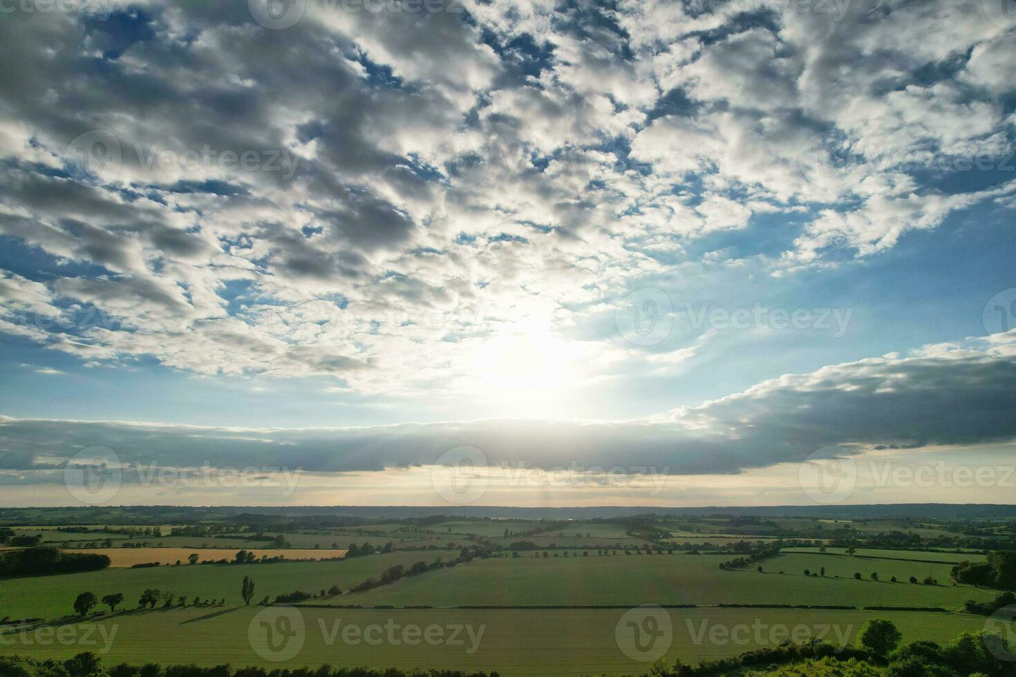 Most Beautiful High Angle view of Dramatical Sky and Clouds over British Countryside Landscape During Sunset photo