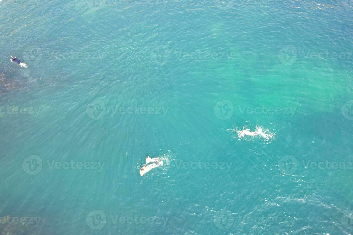 People at Most Beautiful High Angle View of British Landscape and Sea View of Durdle Door Beach of England Great Britain, UK. Image Was captured with Drone's camera on September 9th, 2023 photo